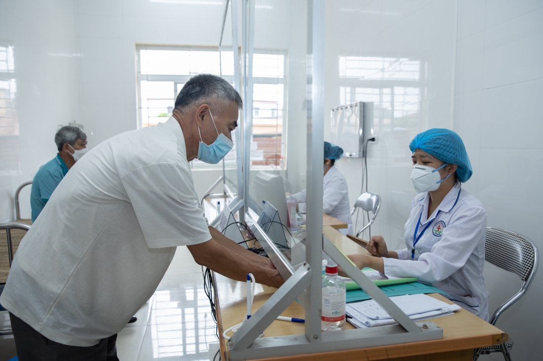 A man provides his TB card to a healthcare provider.